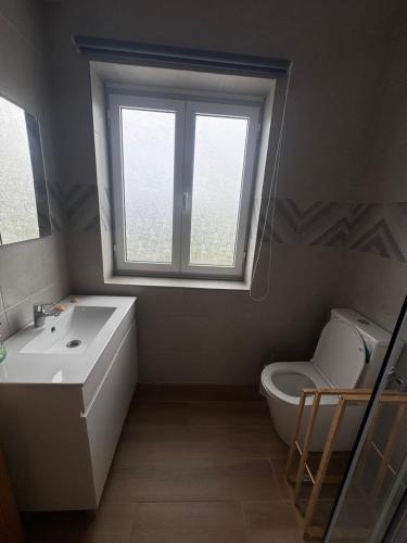 a bathroom with a sink and a toilet and a window at Entre Mar e Vinhas RRAL Nº5668 in Biscoitos