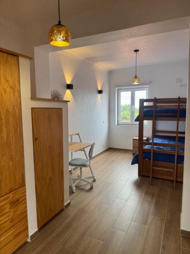 a room with a desk and a bunk bed at Entre Mar e Vinhas RRAL Nº5668 in Biscoitos