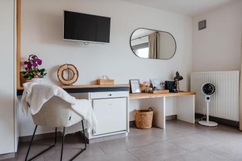 a room with a desk with a chair and a television at Boutique Hotel Het Zoete Zijn in Borgloon