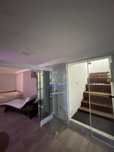 a bathroom with a glass shower and stairs at Mobi Dicky in Nova Friburgo