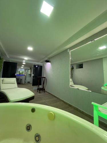 a room with a bath tub and a mirror at Mobi Dicky in Nova Friburgo