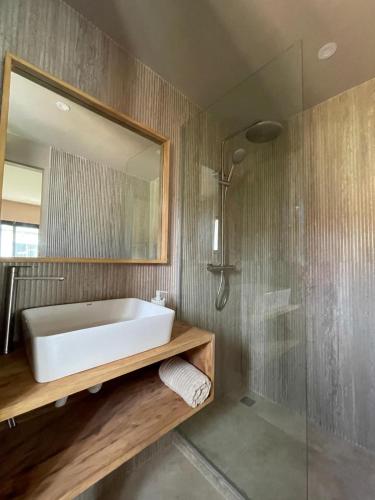 a bathroom with a tub and a shower and a mirror at Nomads Kodjoviakopé in Lomé