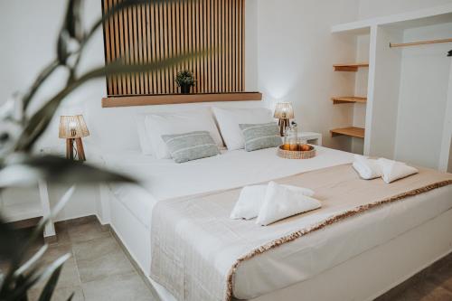 a white bedroom with a large white bed with two lamps at Monopetra View 2 Leros in Nisís Léros