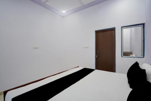a bedroom with a white bed and a window at Hotel O AVS Inn in Bheta