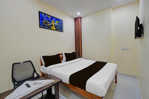 a room with a bed and a table and a chair at Hotel O Moonlight Luxury Rooms in Kāmāreddi