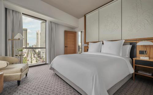 a bedroom with a large white bed and a large window at Four Seasons New Orleans in New Orleans
