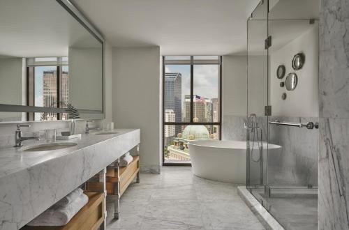 a bathroom with a tub and a large window at Four Seasons New Orleans in New Orleans