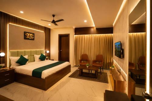 a bedroom with a bed and a desk and chairs at Hotel Royal Villa in Nagpur