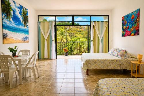 a bedroom with two beds and a table and a window at Casa Esperanza in Playa Estacahuite