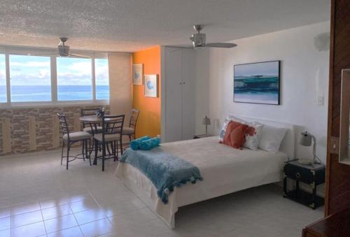 a bedroom with a bed and a table with chairs at KASA Emmas Ocean View in San Juan