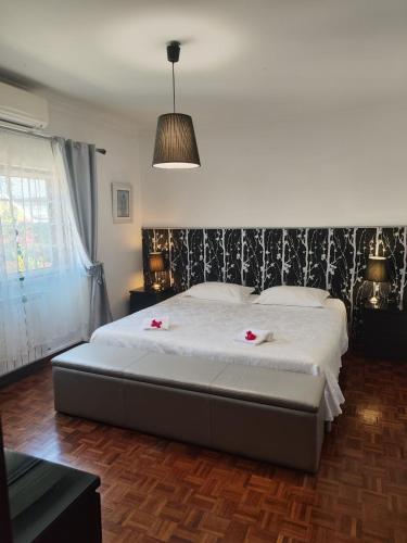 a bedroom with a large bed with pink flowers on it at Hostel Casa Lucas in Charneca
