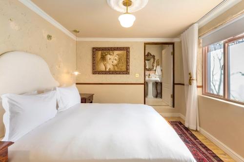 a bedroom with a white bed and a window at Royva Bo-Kaap in Cape Town