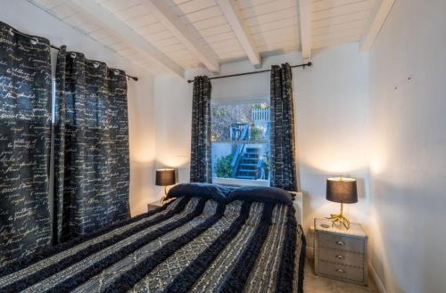 a bedroom with a bed and a window at Malibu Surf Cottage on Lechuza Beach in Malibu
