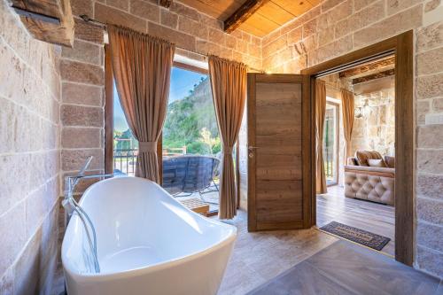 a bathroom with a tub and a view of a room at VILA K3 Komarnica in Šavnik