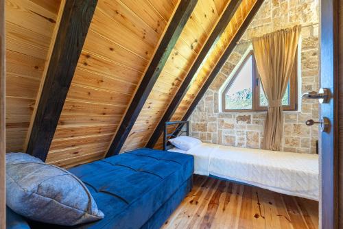 a room with a bed and a window in a attic at VILA K3 Komarnica in Šavnik