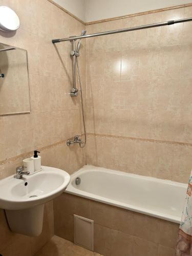 a bathroom with a sink and a bath tub at Central apartment in Razlog