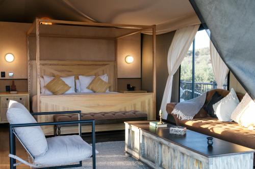 a bedroom with a bed and a couch and a chair at Hotel Omún, San Miguel de Allende in Dolores Hidalgo