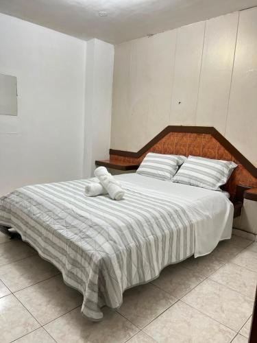 a bedroom with a large bed with white sheets and pillows at Pension Calidonia in Panama City
