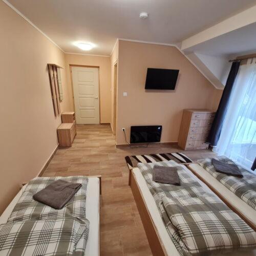 a room with two beds in a room at Pitvar Vendégház in Zalaegerszeg
