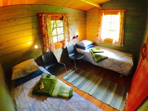 a room with two beds and two chairs and two windows at Kuivastujaani in Kuivastu