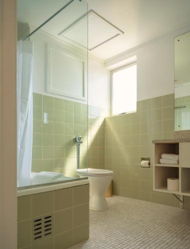 a bathroom with a tub and a toilet and a sink at Bay Plaza Hotel in Wellington