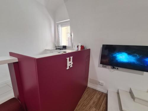 a purple cabinet in a room with a flat screen tv at Horizon Suite Bellavista in Catanzaro