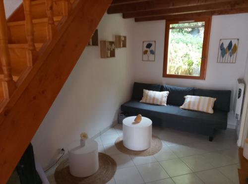 a living room with a blue couch and a window at Mazet du bonheur in Saint-Martin-de-Brômes