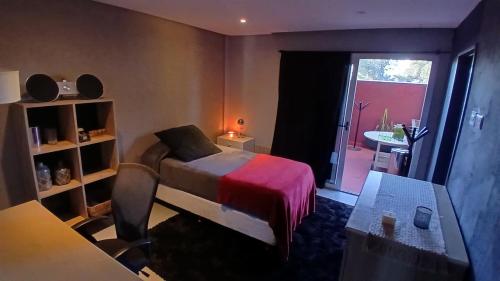 a bedroom with a bed and a desk and a table at MiCASA in Córdoba