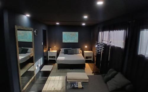 a bedroom with a bed and a couch and a mirror at MiCASA in Córdoba