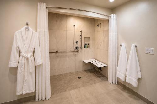 a bathroom with a shower and a robe on a wall at Wayside Inn in Carmel