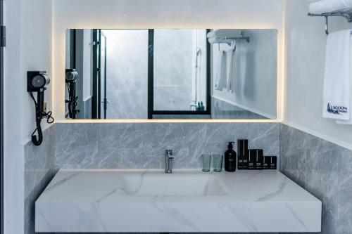 a bathroom with a sink with a mirror at Lagoon Dhigurah in Dhigurah