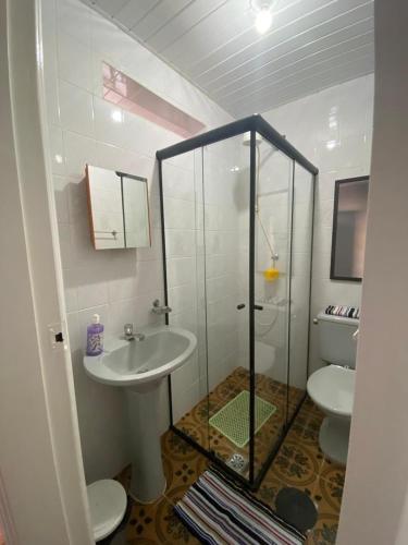 a bathroom with a glass shower and a sink at Recanto da Matriz - Águas da Prata in Águas da Prata
