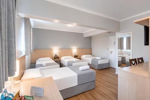 ein Wohnzimmer mit Sofa und Tisch in der Unterkunft Bristol Sabrina Hotel de Charme Joinville in Joinville