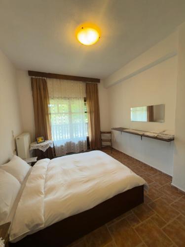 a bedroom with a large white bed and a window at Hause Sogambros 2 in Taxiarchis
