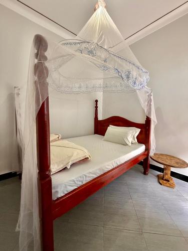 a bedroom with a bed with a canopy at Murchison Close Motel in Masindi