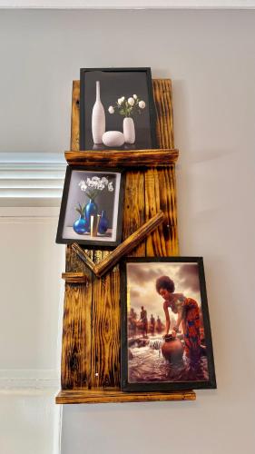 a shelf with pictures and vases on a wall at Murchison Close Motel in Masindi