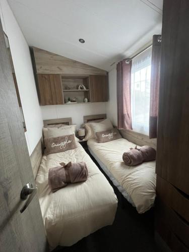 two beds in a small room at Beautiful 3 Bed Caravan with Views & Decking in Mortehoe