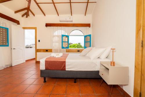 a bedroom with a large bed with a window at Hotel Crossman in Puerto Ayora