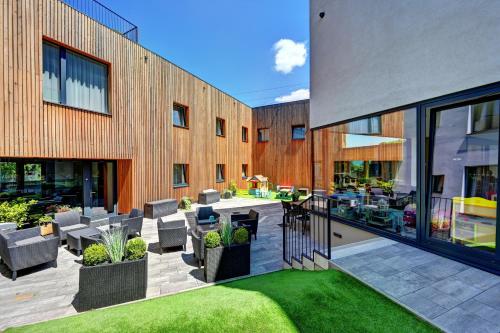 an outdoor patio with chairs and a table in front of a building at Wellness Hotel Fénix in Liberec