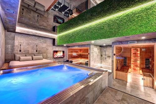 a hot tub in a room with a bed and a fireplace at Wellness Hotel Fénix in Liberec