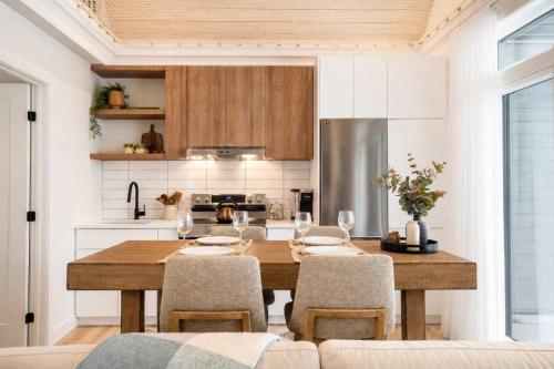 a kitchen with a wooden table and chairs and a kitchen with a kitchen at Modern Comfort - Spa - Mountain - Chalet ALBA in Saint Come