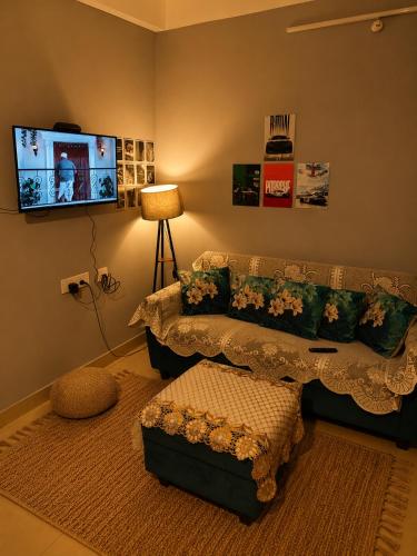 a living room with a couch and a flat screen tv at Elyvia Stays in Guwahati