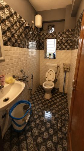 a bathroom with a toilet and a sink at Elyvia Stays in Guwahati
