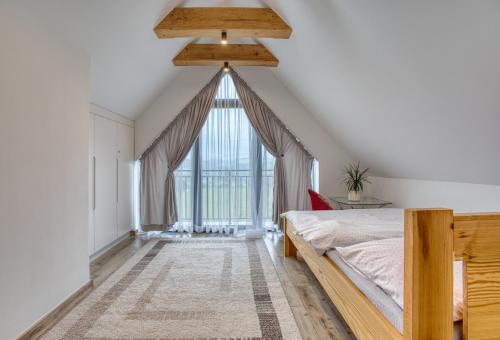 a bedroom with a bed and a large window at Mery House Agroturystyka in Biały Dunajec