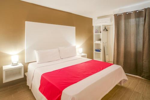 a bedroom with a large bed with a red blanket at Valentina Suites by Las Flores Vacation Rentals in Playa del Carmen