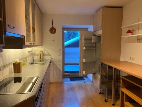 a kitchen with a sink and a door to a yard at Berghaus Appartment in Biberwier