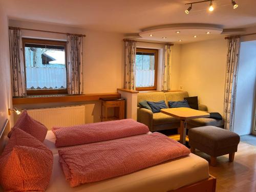 a room with a bed and a couch and a chair at Berghaus Appartment in Biberwier