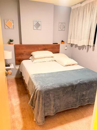 a bedroom with a large bed with a wooden headboard at Apto Amoblado Luxury in Bucaramanga