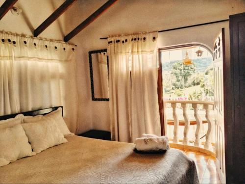 a bedroom with a large bed and a window at La Cabaña Paraíso Verde Suaita in Suaita