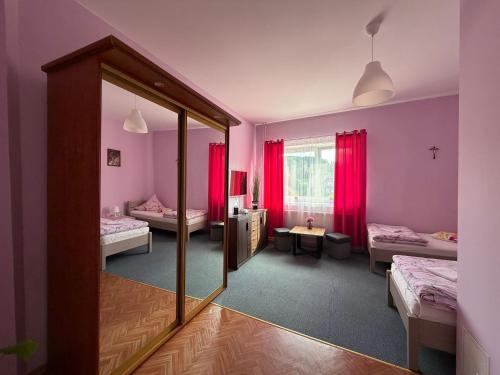 a room with two beds and a mirror at Agroturystyka ''Dom Pod Karpiem'' in Zagórze Śląskie